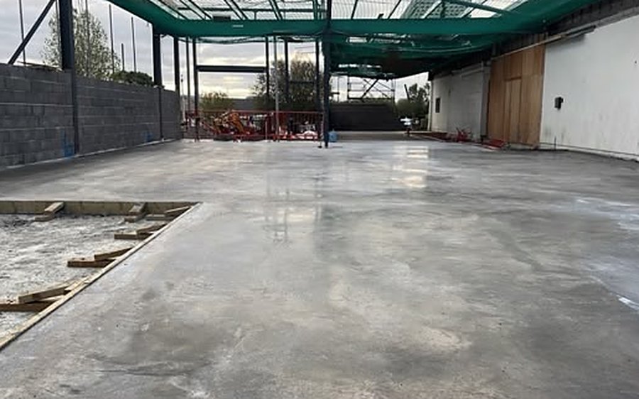 Power floated concrete floor slab inside a steel framed extension